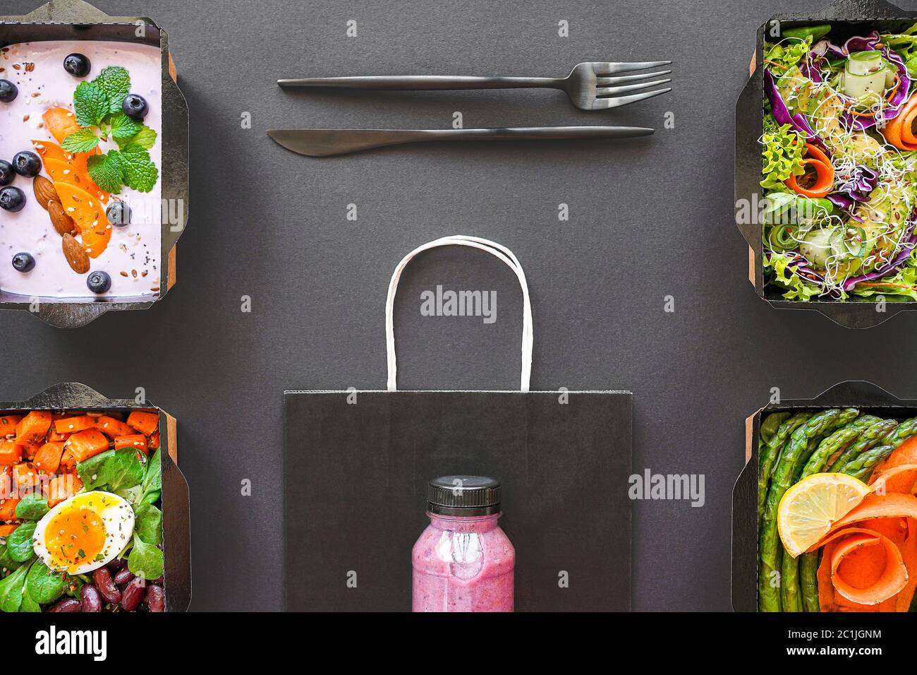 Vegan pacchetto di alimenti sani scatole di consegna di verdure isolate su tavola nera. Foto Stock