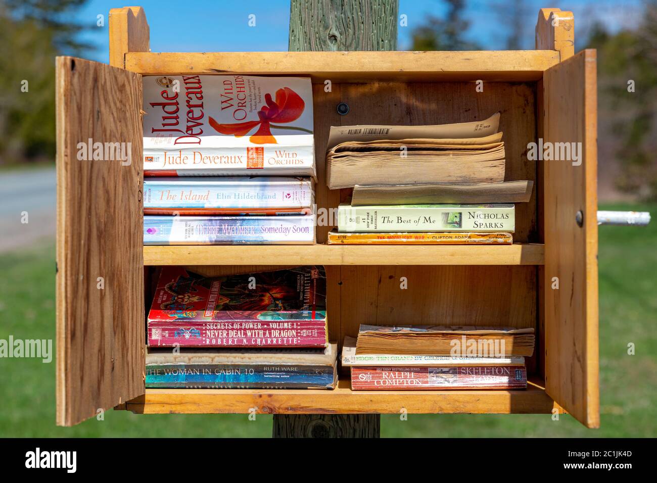 Rural New Brunswick, Canada - 17 maggio 2020: Una piccola biblioteca su un polo di potere sul lato di una strada. La biblioteca è aperta e mostra una varietà di libri. Foto Stock