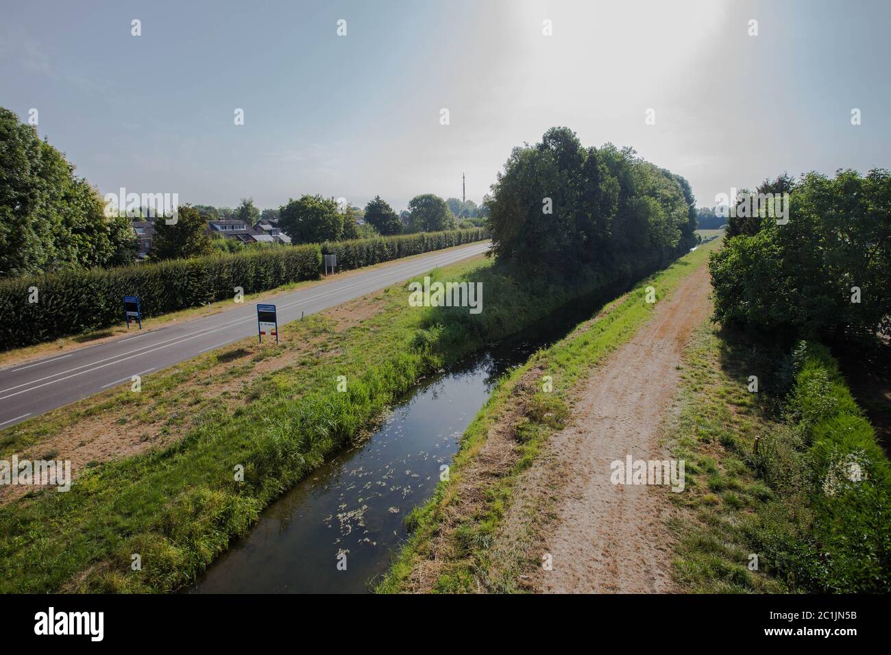 Una strada che conduce ad una tranquilla e residenziale area di vicinato con il tradizionale stile olandese case durante il tramonto. Foto Stock