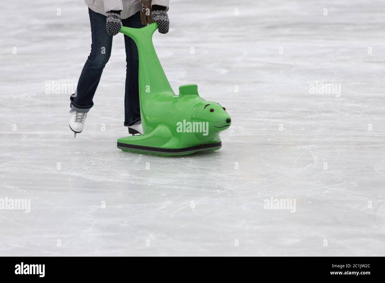 Skater aiuta a mantenere l'equilibrio sul ghiaccio. Donna sul pattino della figura con figura imparante all'aperto sulla pista di pattinaggio del ghiaccio, spazio di copia Foto Stock