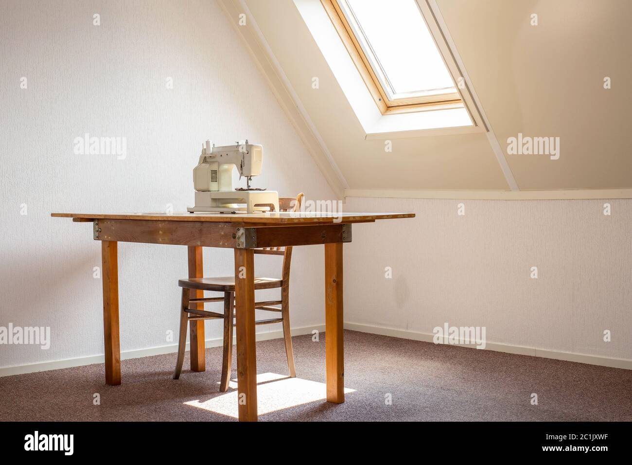 Macchina da cucire sul tavolo in un atelier studio, lavoro o sala hobby Foto Stock
