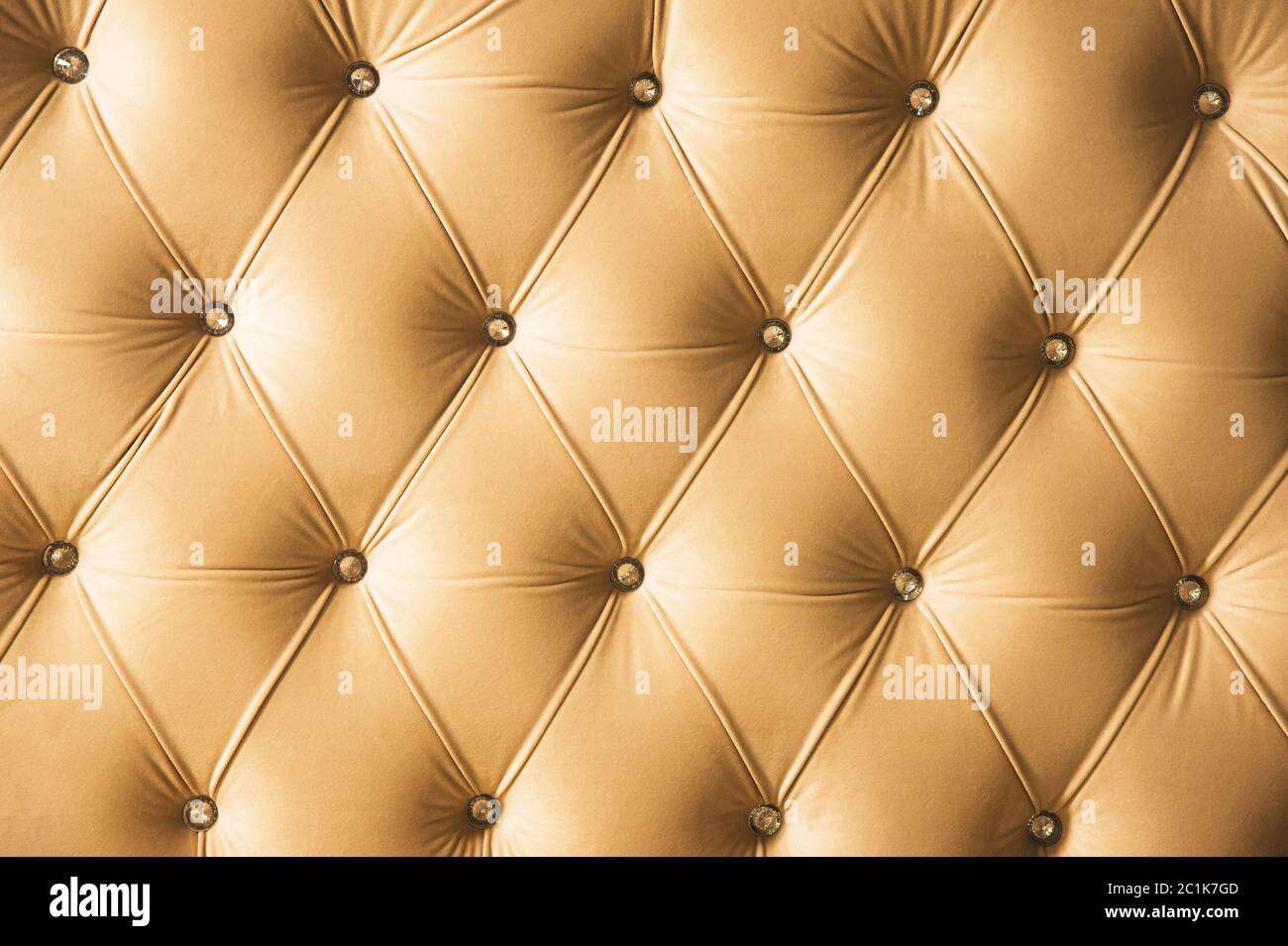 Fondo tessile beige morbido con bottoni simmetrici sugli angoli dei diamanti. Elementi di arredamento morbidi e costosi. Lusso Foto Stock