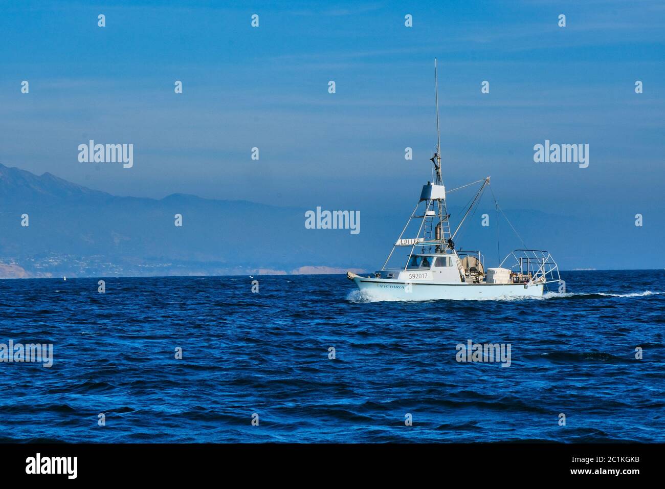 Barca Fishing nel Blue Harbour Foto Stock