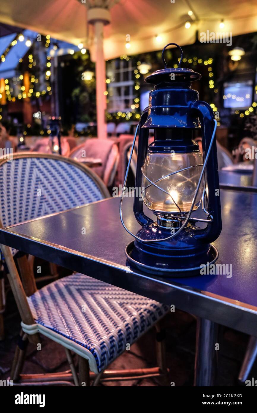 Luce magica da una tradizionale lanterna su un tavolo da ristorante a Copenhagen. Luci e decorazioni natalizie intorno. Ambiente misterioso per un tour Foto Stock