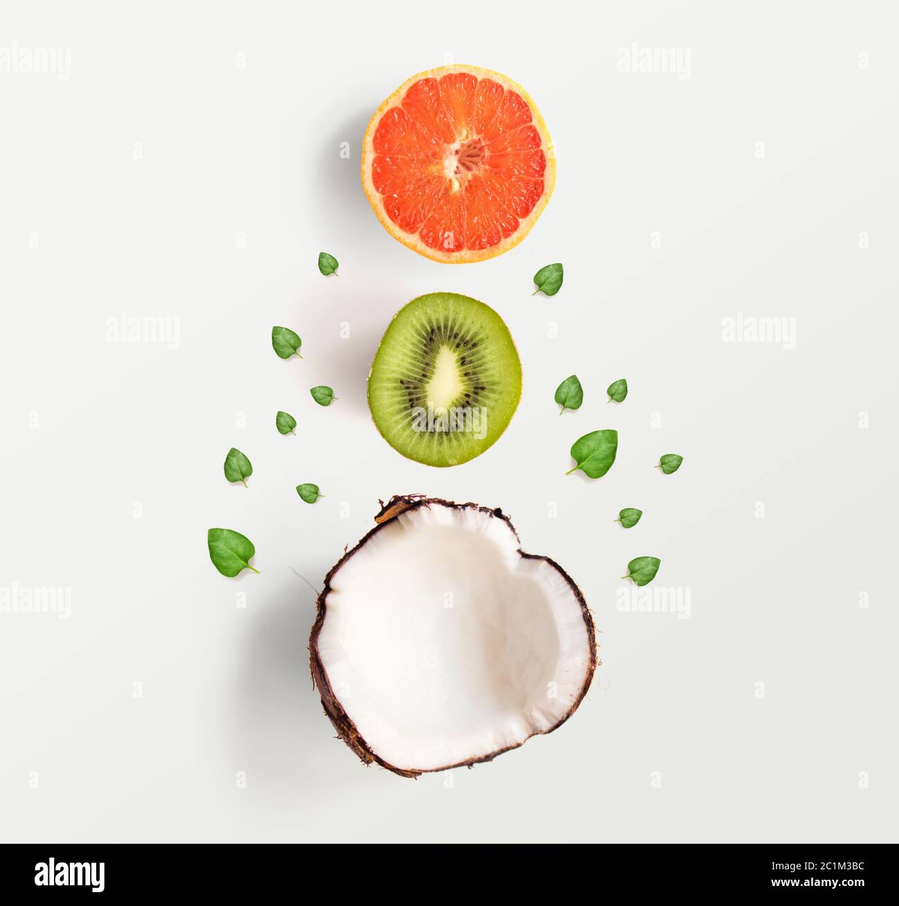 Layout creativo fatto di noci di cocco e foglie. Disposizione piatta. Concetto di cibo. Cocco su sfondo rosa. Foto Stock