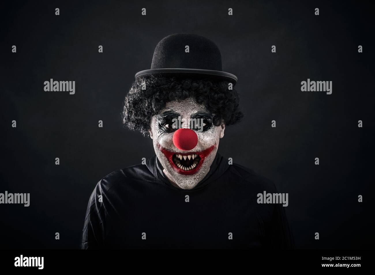 Scary clown che mostra i suoi affilati denti appuntiti Foto Stock