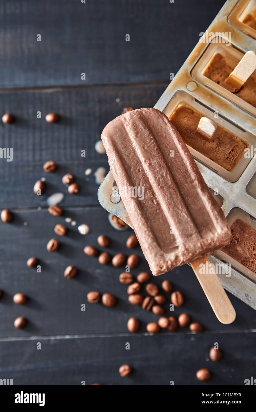 Classico congelatore a stampo per popsicle per ghiaccio fatto in casa in estate su sfondo scuro in legno, vista dall'alto Foto Stock