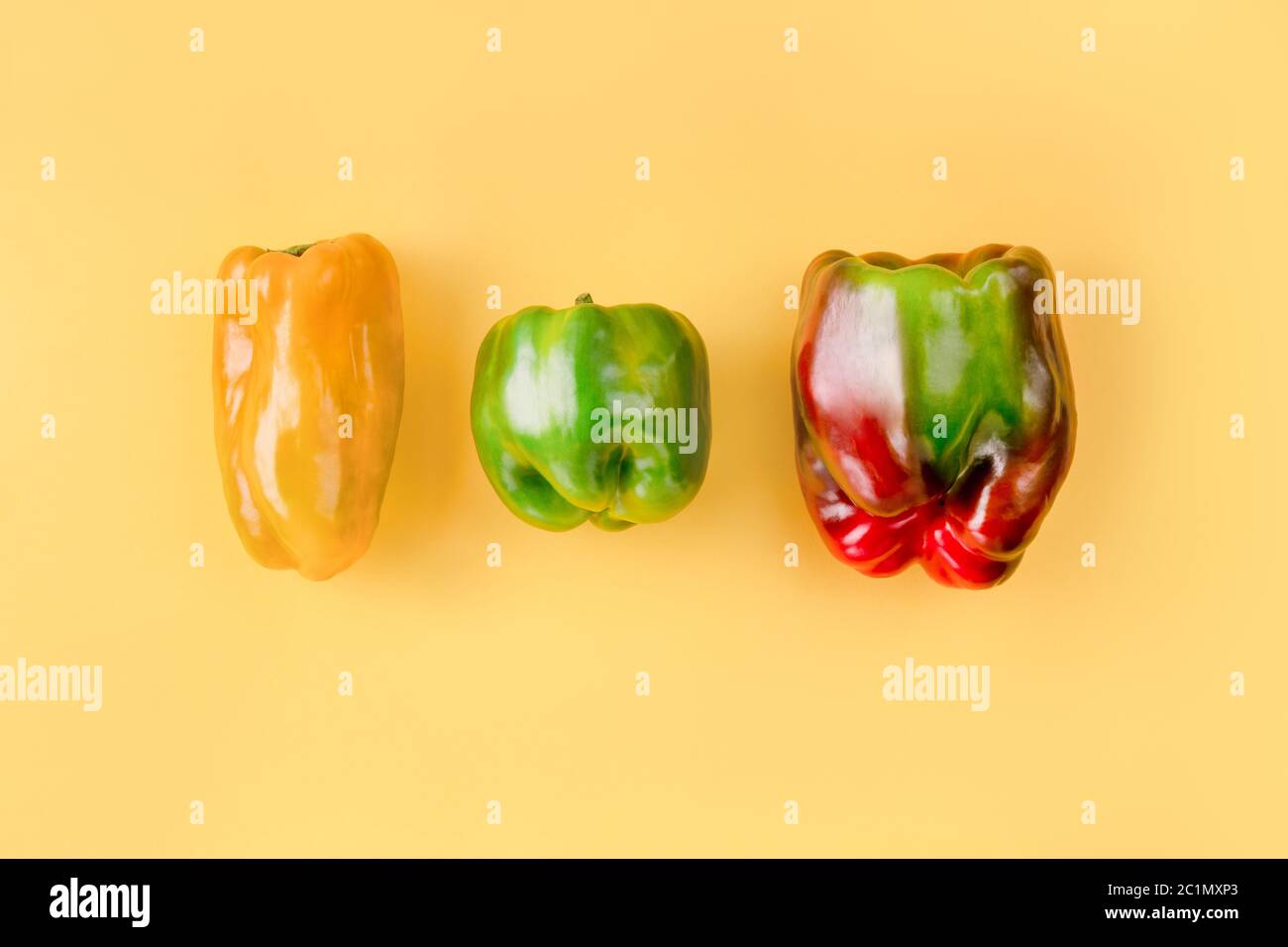 Layout creativo di peperoni colorati su sfondo arancione chiaro. Foto Stock