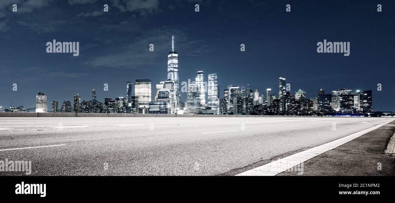 vuota autostrada asfaltata con moderno paesaggio urbano di notte a new york Foto Stock