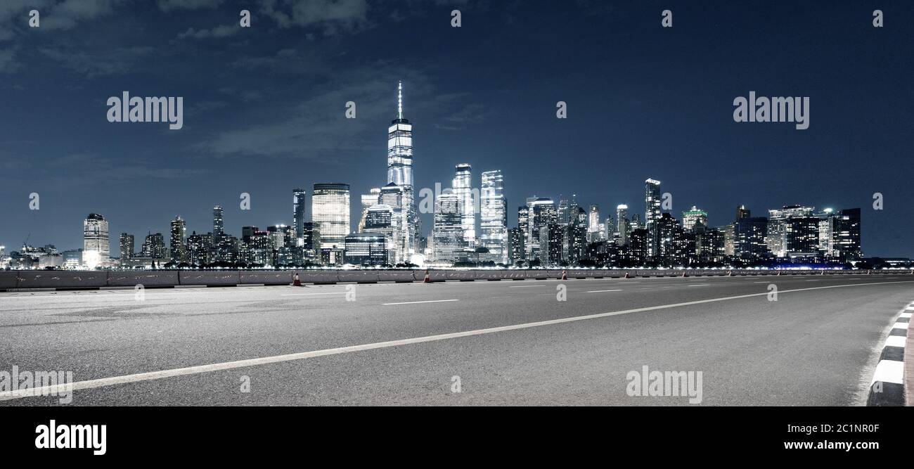 vuota autostrada asfaltata con moderno paesaggio urbano di notte a new york Foto Stock
