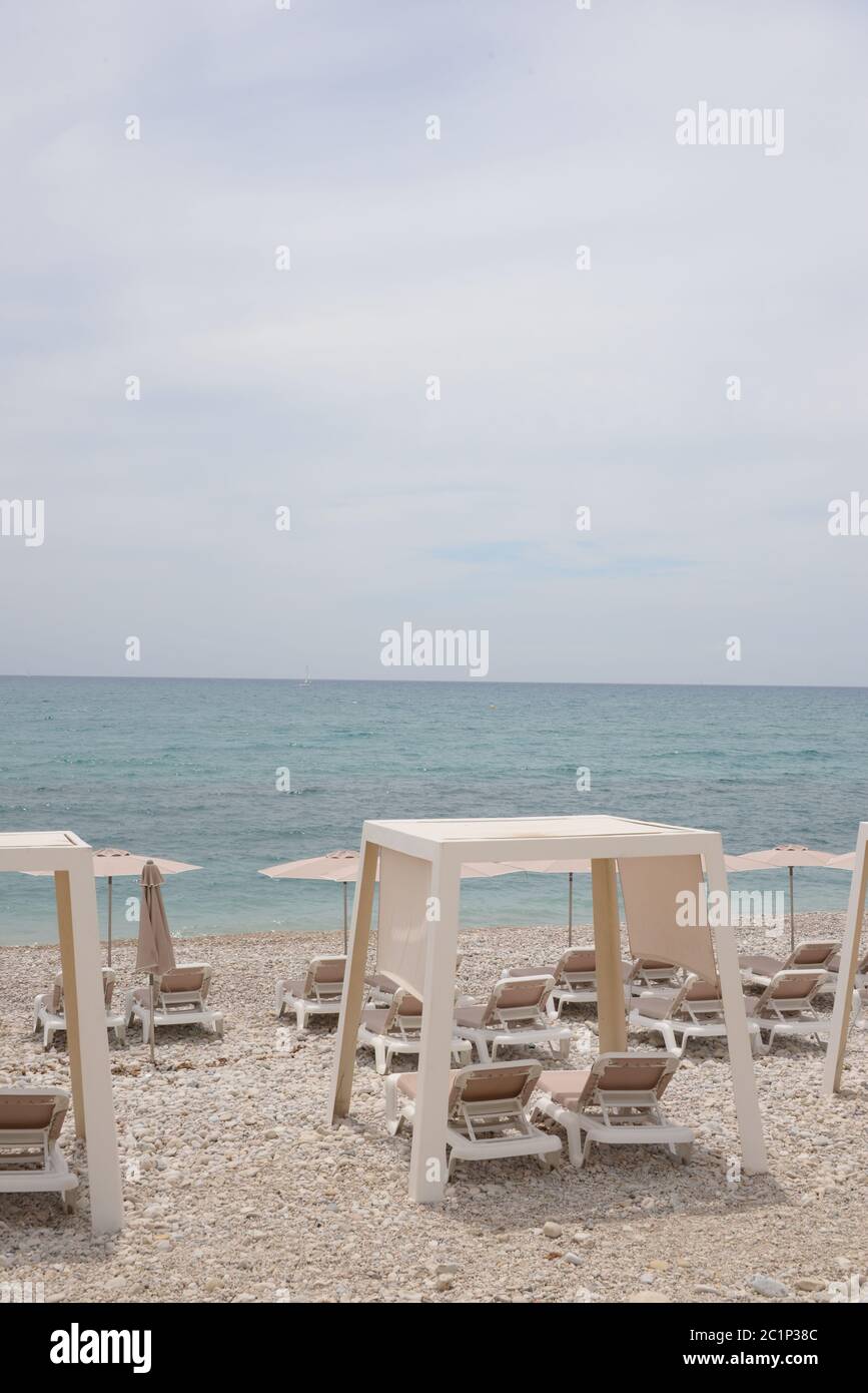 Sedie a sdraio e grandi, piccole, pietre rotonde sul Mediterraneo nella provincia di Alicante, Spagna Foto Stock