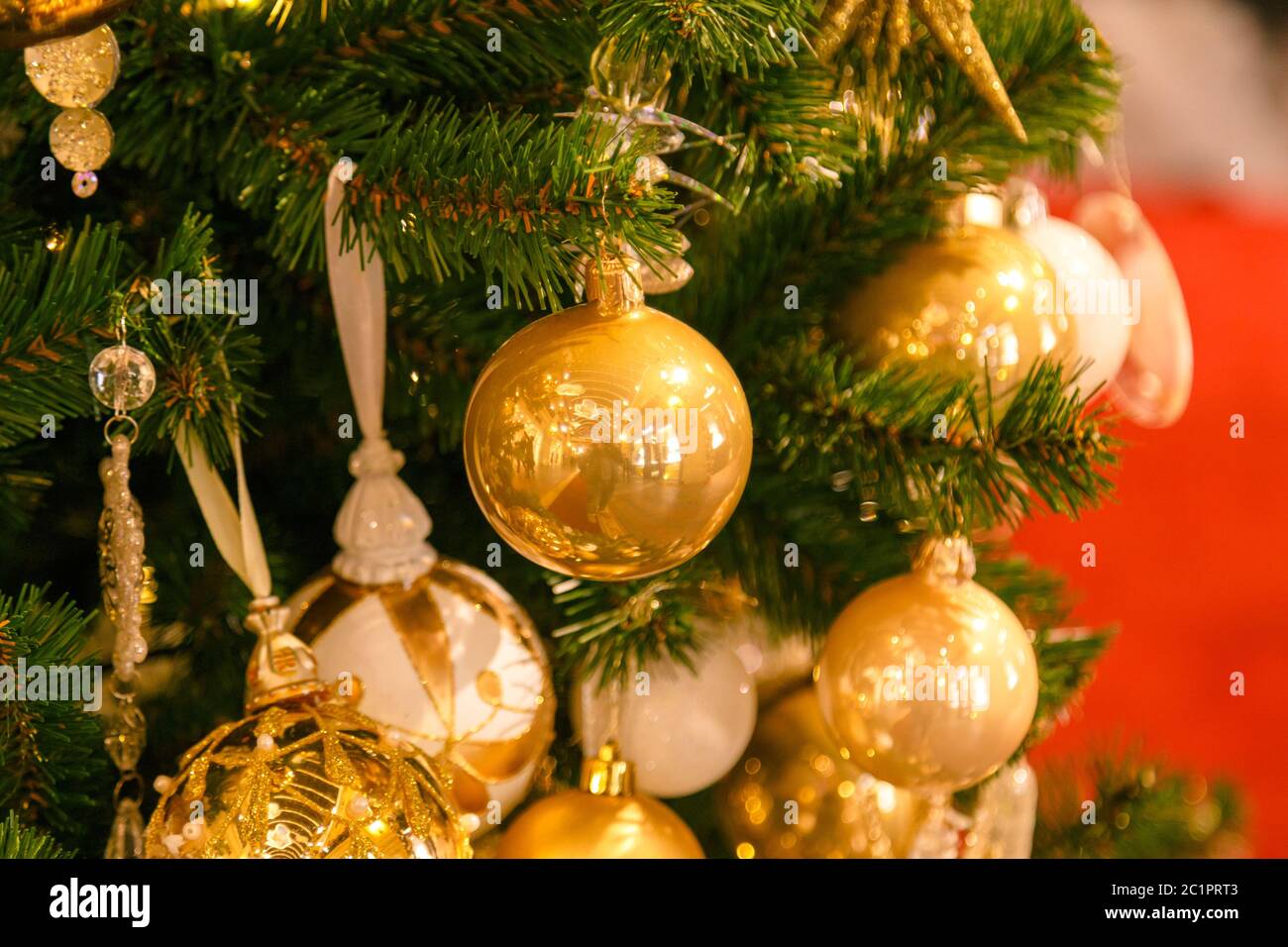 Ornamenti rossi di Natale e tavola con cono di pino decorato innevato centrotece. Nuovo anno di fondo con disposizione in vimini cesto Foto Stock