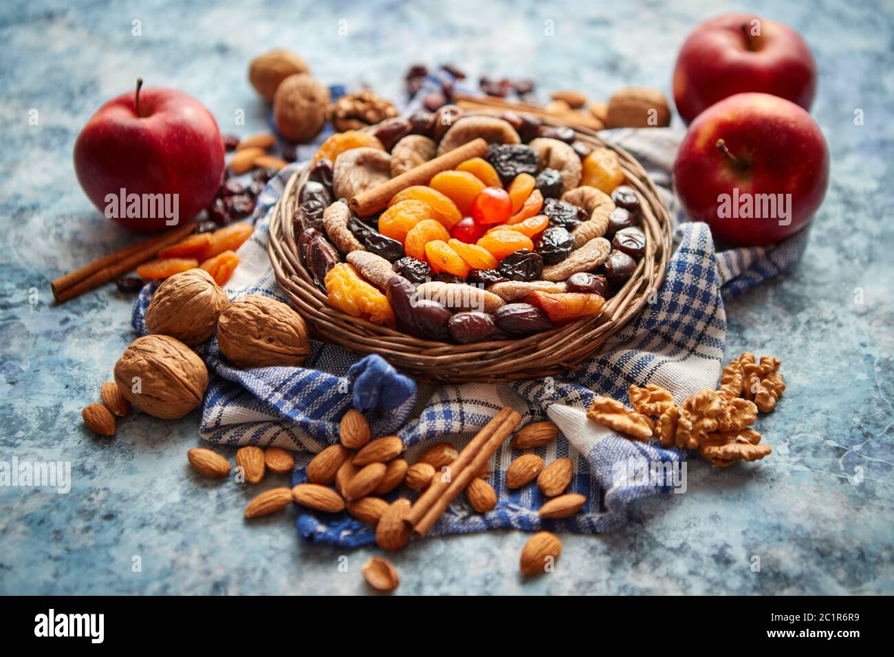 Composizione di frutta secca e noci in piccolo vaso in vimini collocato sul tavolo di pietra Foto Stock