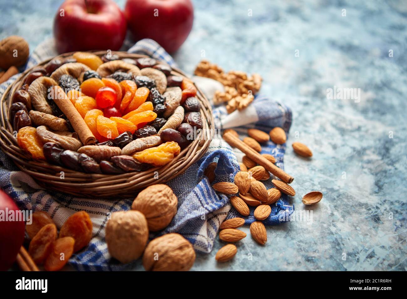 Composizione di frutta secca e noci in piccolo vaso in vimini collocato sul tavolo di pietra Foto Stock