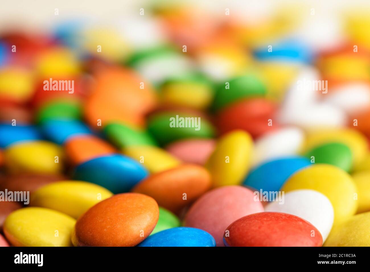 caramelle rotonde colorate sparse sul piano d'esame Foto stock - Alamy
