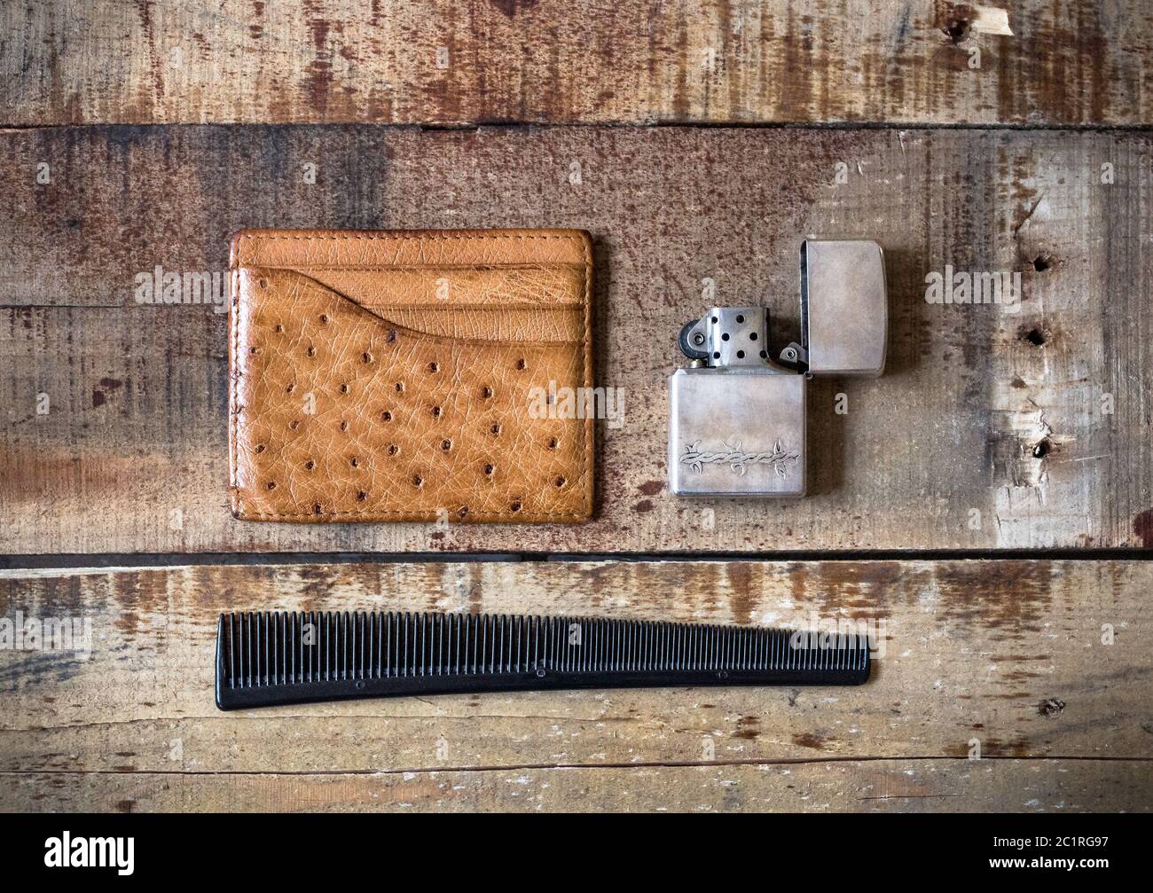 accessori uomo con accendino, pettine e portafoglio carte su sfondo in  legno Foto stock - Alamy