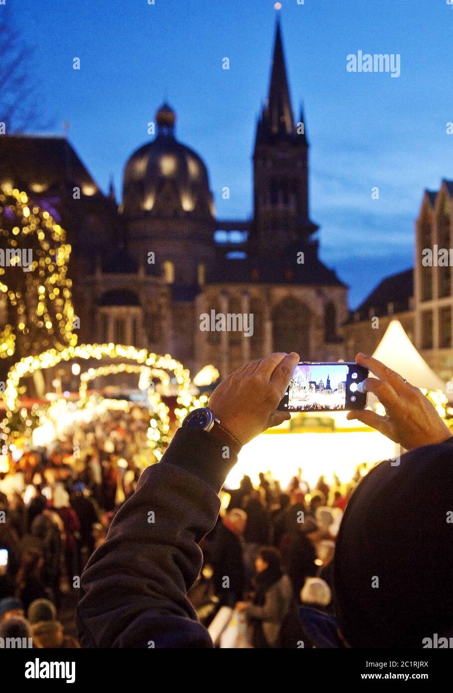 Uomo che fa foto del mercatino di Natale alla Cattedrale di Aquisgrana in serata, Aquisgrana, Germania Foto Stock