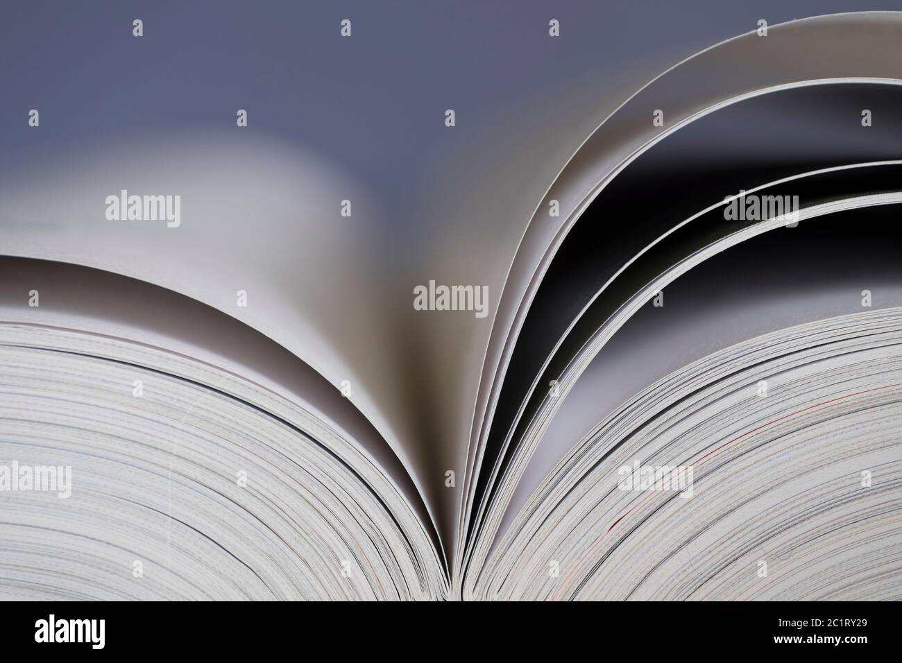 Apri il libro con le pagine aperte e uno sfondo bluastro. Profondità di campo ridotta Foto Stock