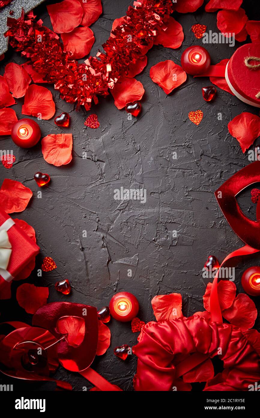 Petali di rose rosse, candele, accessori di datazione, regali in scatola, cuori, paillettes Foto Stock