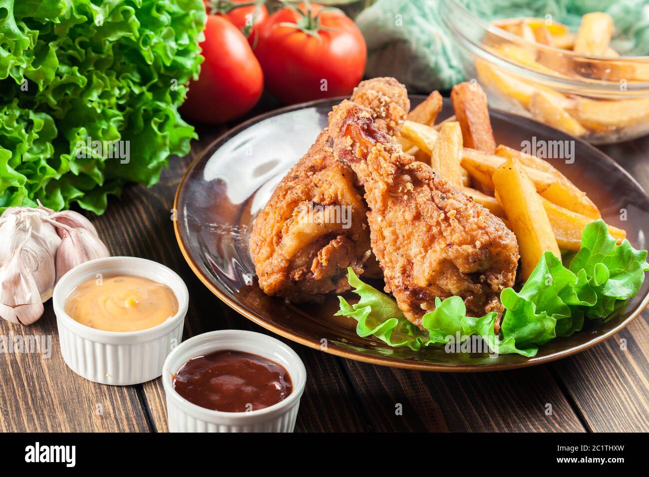 Cosce di pollo fritte del kentucky croccanti con patatine fritte in un piatto Foto Stock