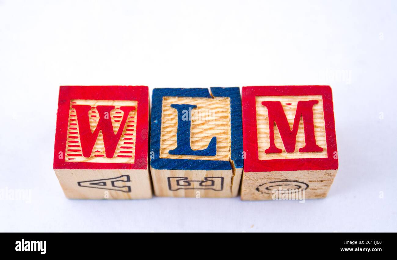 L'abbreviazione WLM è visualizzata visivamente su uno sfondo chiaro utilizzando un'immagine colorata in blocchi di legno con spazio di copia in formato orizzontale Foto Stock