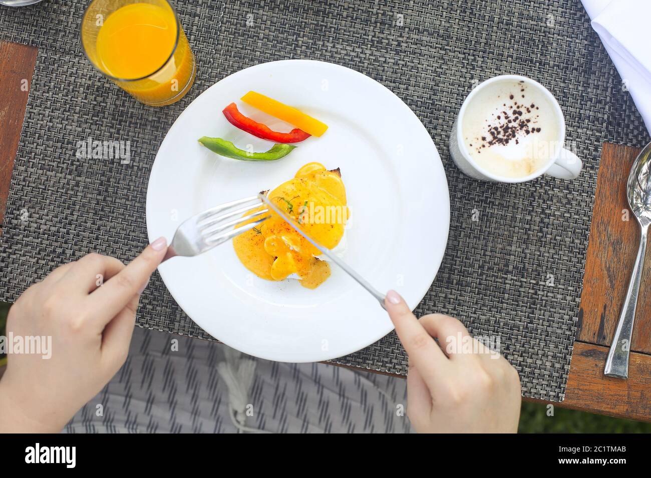 Immagine ritagliata di persona che mangia uova benedetto ad un tavolo da caffè Foto Stock
