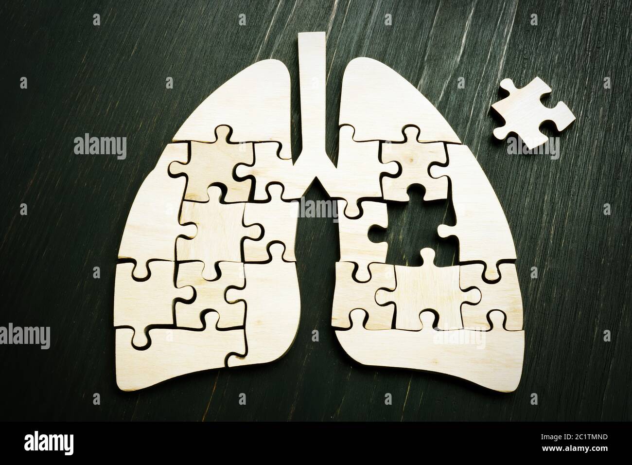 Cancro polmonare o concetto di malattia respiratoria. Puzzle di legno sulla superficie scura. Foto Stock