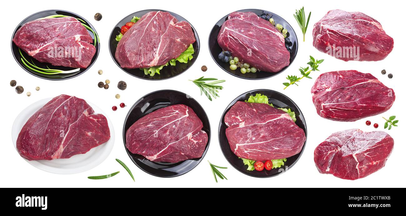 Pezzo di carne di manzo crudo sulla piastra nera isolati su sfondo bianco, collezione con erbe e spezie Foto Stock