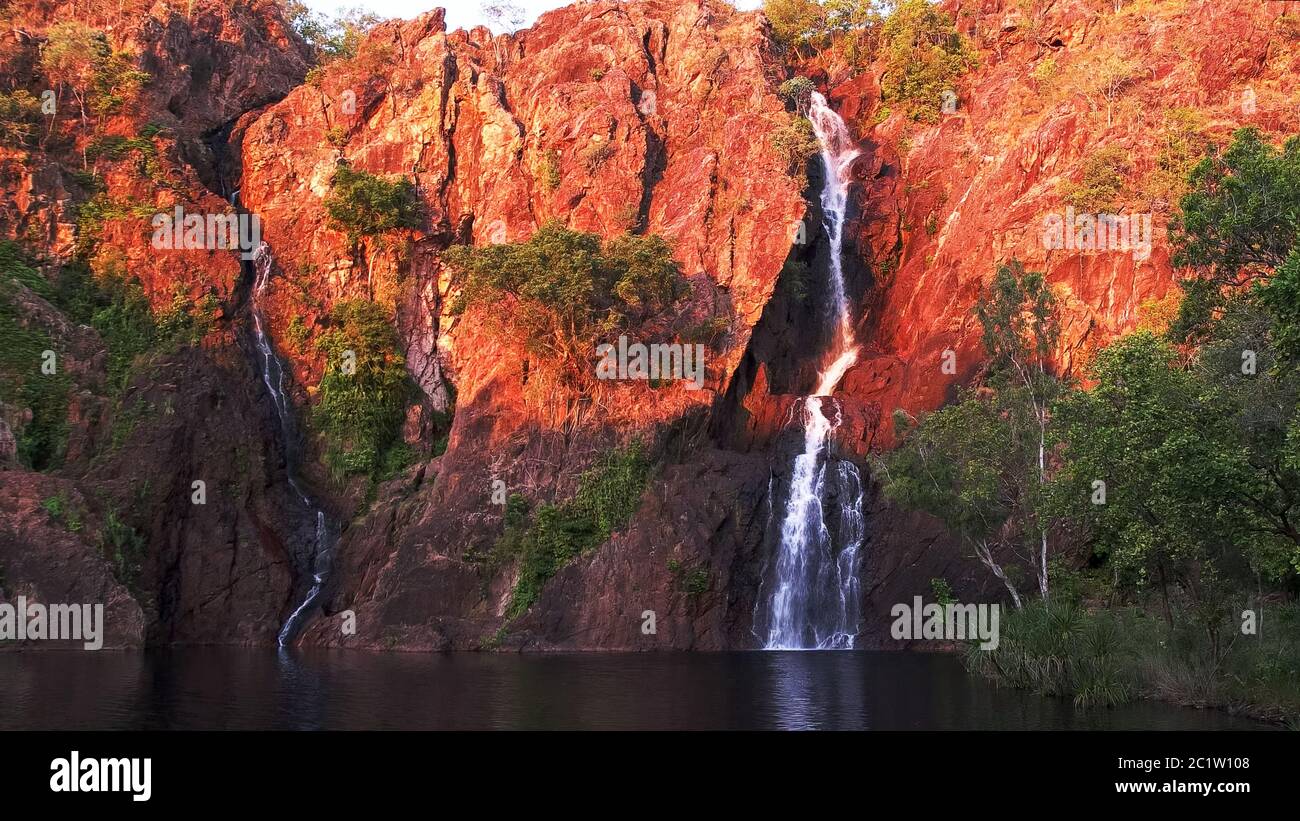 Regolazione del sole trasforma le scogliere a wangi cascate nel parco nazionale di Litchfield un rosso brillante Foto Stock