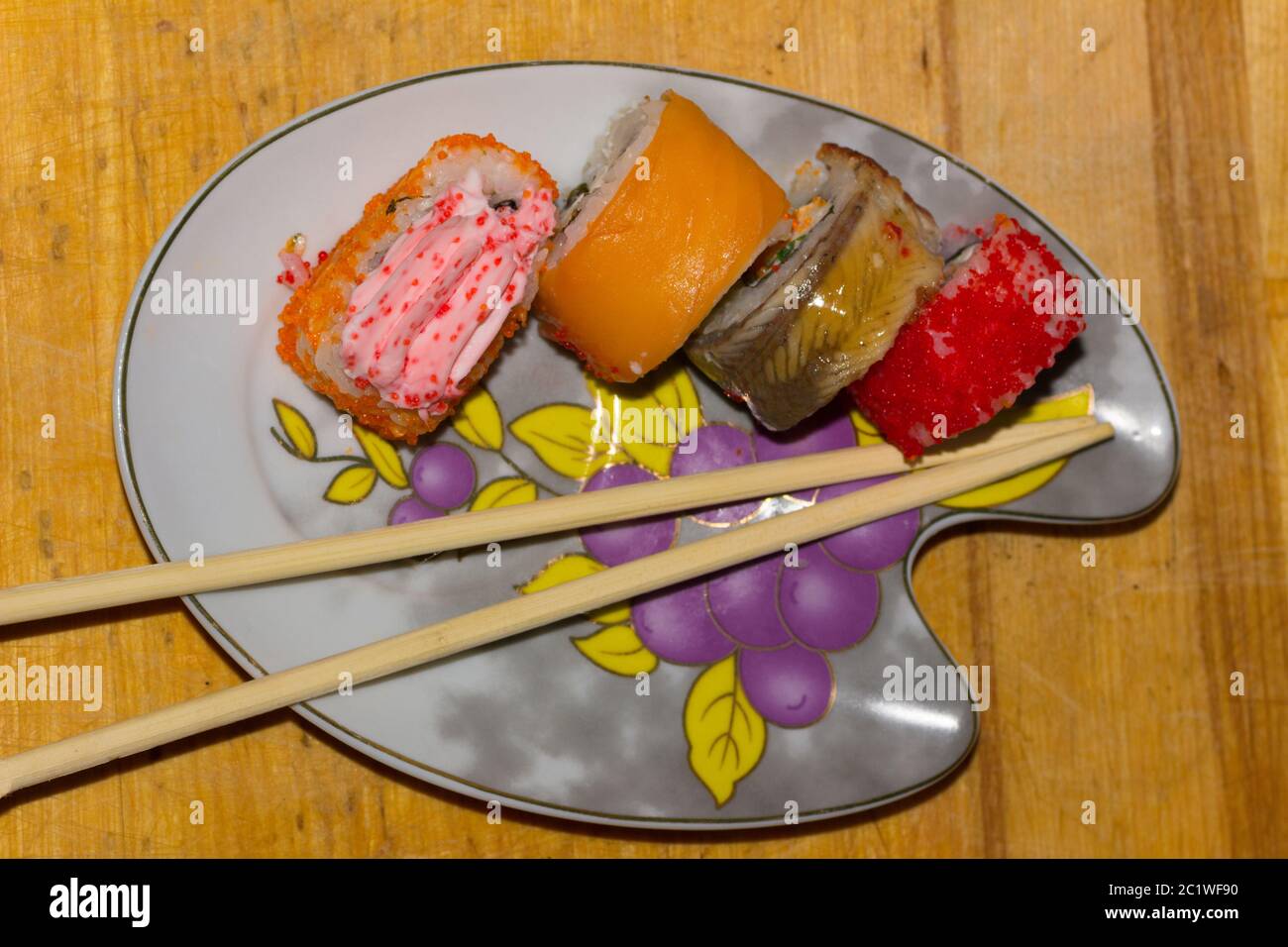 Rotoli di Sushi con salmone, anguilla, crema di formaggio Philadelphia, caviale tobica e cibo bastoni sullo sfondo di legno Foto Stock
