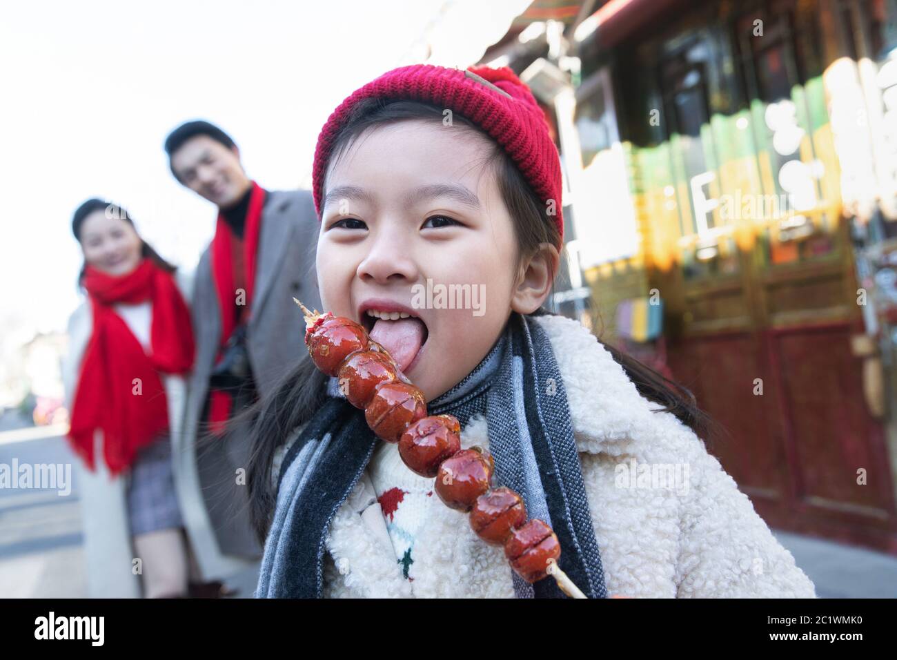 Felice bambina mangiare zucchero-rivestito bacche Foto Stock