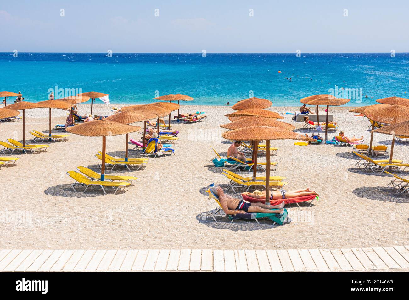 Spiaggia dell'isola greca lettini con ombrelloni, Rodi, Isola di Rodi, Dodecanese, Grecia Foto Stock