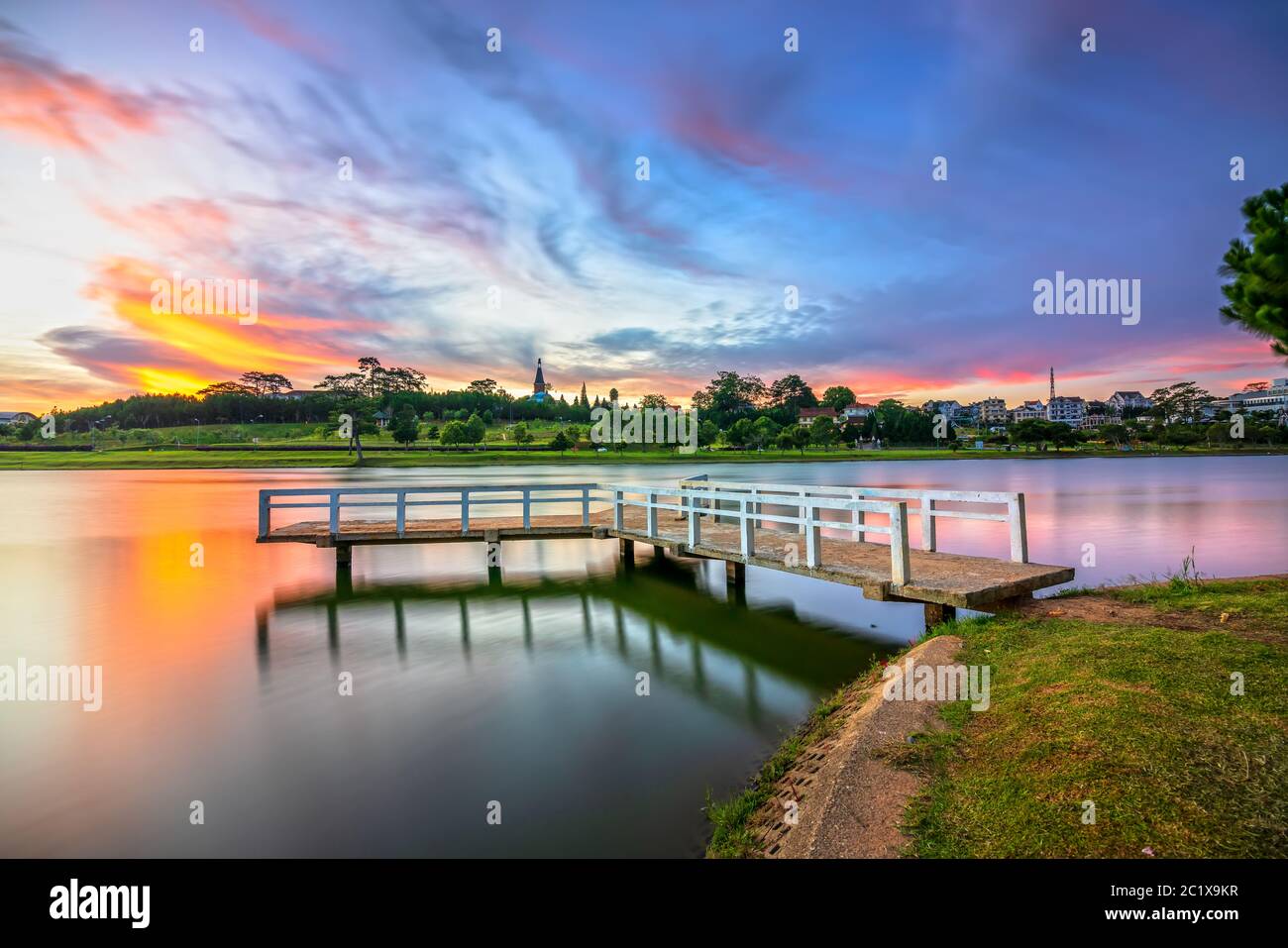 Alba sul piccolo ponte che si affaccia sul lago con il drammatico sky accoglie con favore il nuovo giorno nella città turistica del Vietnam Foto Stock