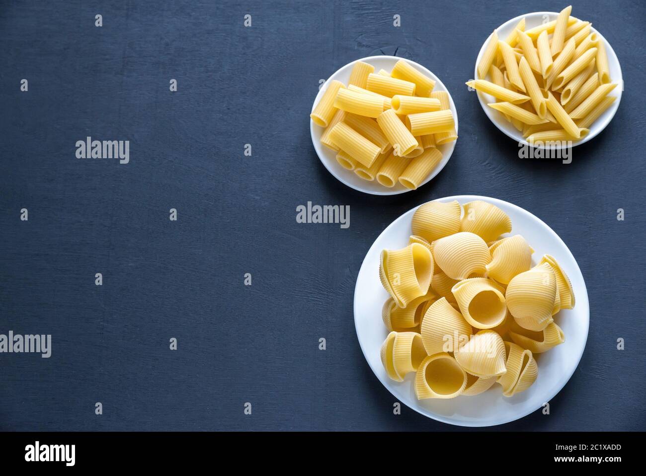 Vari tipi di pasta su sfondo scuro Foto Stock