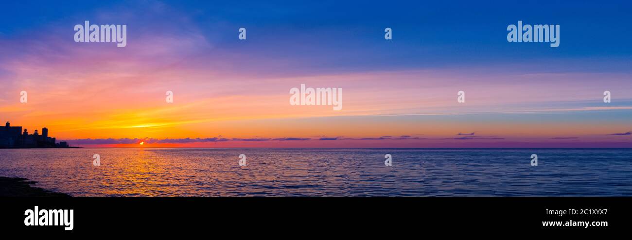 Tramonto sul Malecon e Oceano Atlantico con edificio residenziale in background - Havana, Cuba Foto Stock