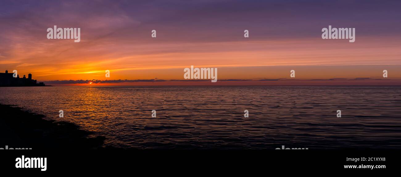 Tramonto sul Malecon e Oceano Atlantico con edificio residenziale in background - Havana, Cuba Foto Stock