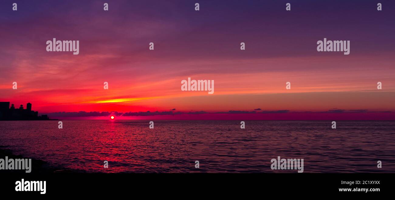 Tramonto sul Malecon e Oceano Atlantico con edificio residenziale in background - Havana, Cuba Foto Stock