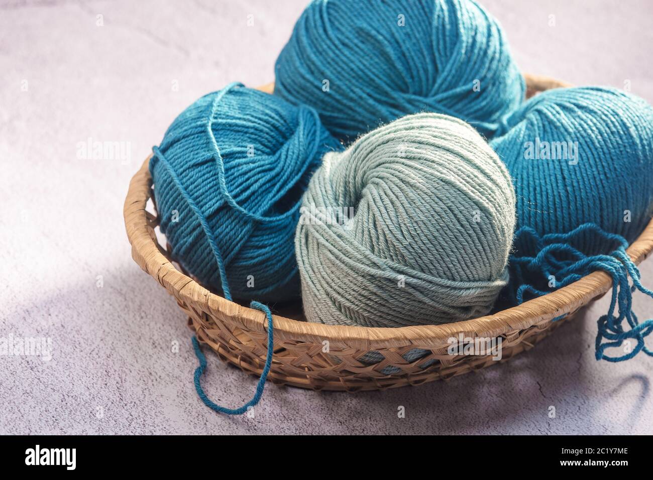 balls of colored yarn in a wicker basket close-up Foto Stock