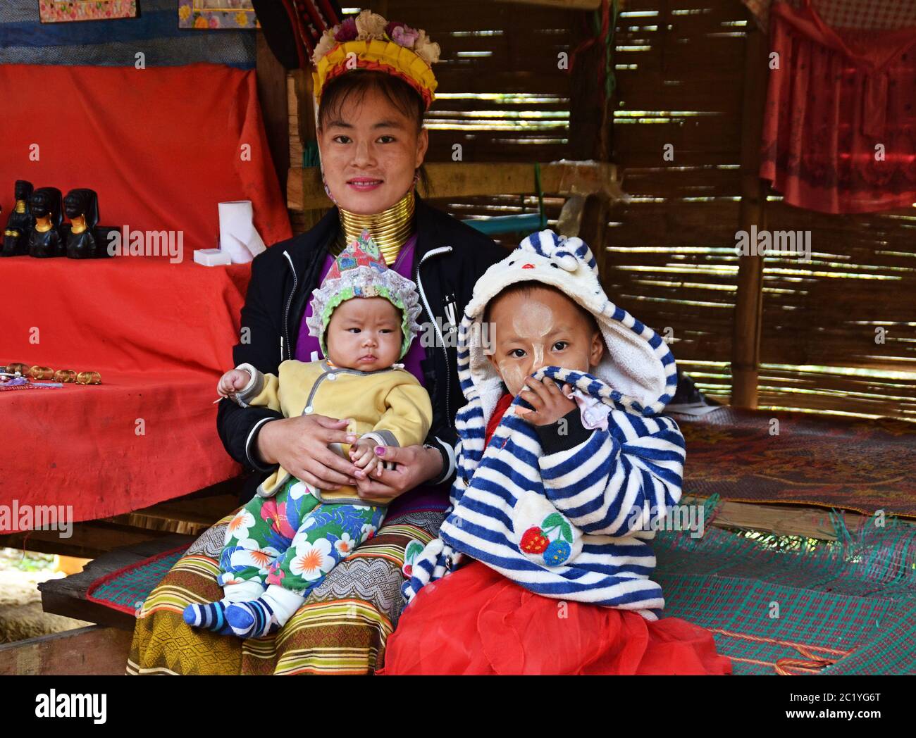 Donna Kayan thailandese a collo lungo (donna giraffa) con due bambini. Foto Stock