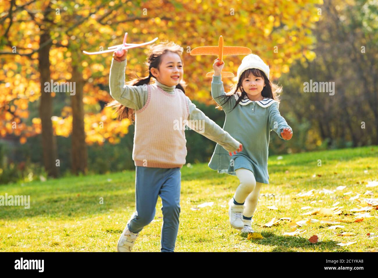 Le ragazze giocano nel parco con un aereo giocattolo Foto Stock