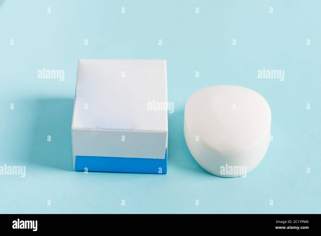 Saponetta naturale aromatica e scatola di carta bianca bianca per il confezionamento su sfondo blu pastello. Mock-up per il tuo design e la tua creatività. Foto Stock