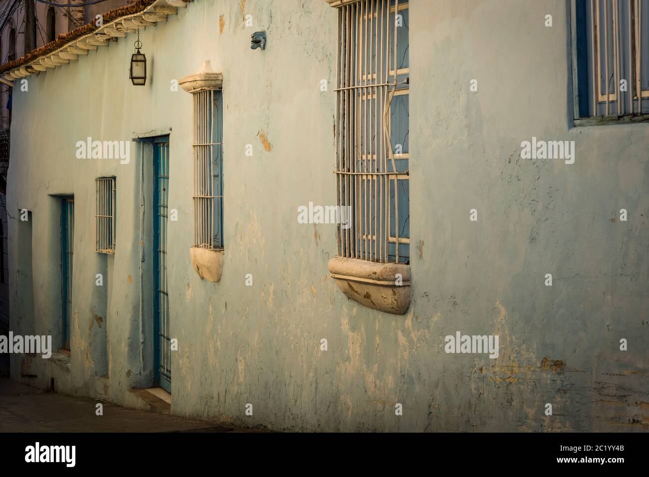 Casa dipinta di colore pastello con bar finestra nel centro della città coloniale, Santiago de Cuba, Cuba Foto Stock