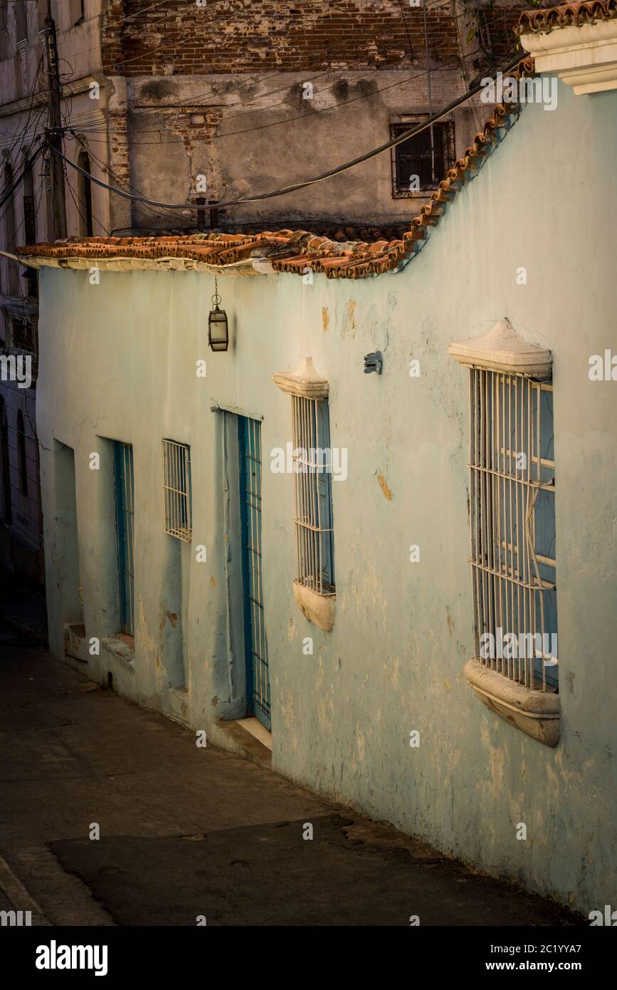 Casa dipinta di colore pastello con bar finestra nel centro della città coloniale, Santiago de Cuba, Cuba Foto Stock