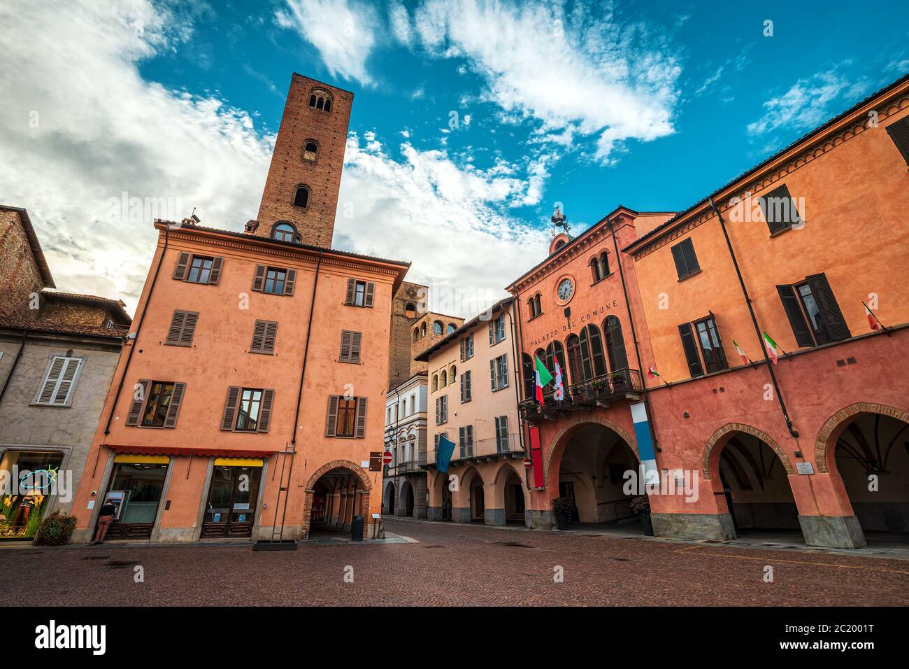 Vecchie case colorate e torre medievale su piazza acciottolata nella città di Alba, Piemonte, Italia settentrionale. Foto Stock