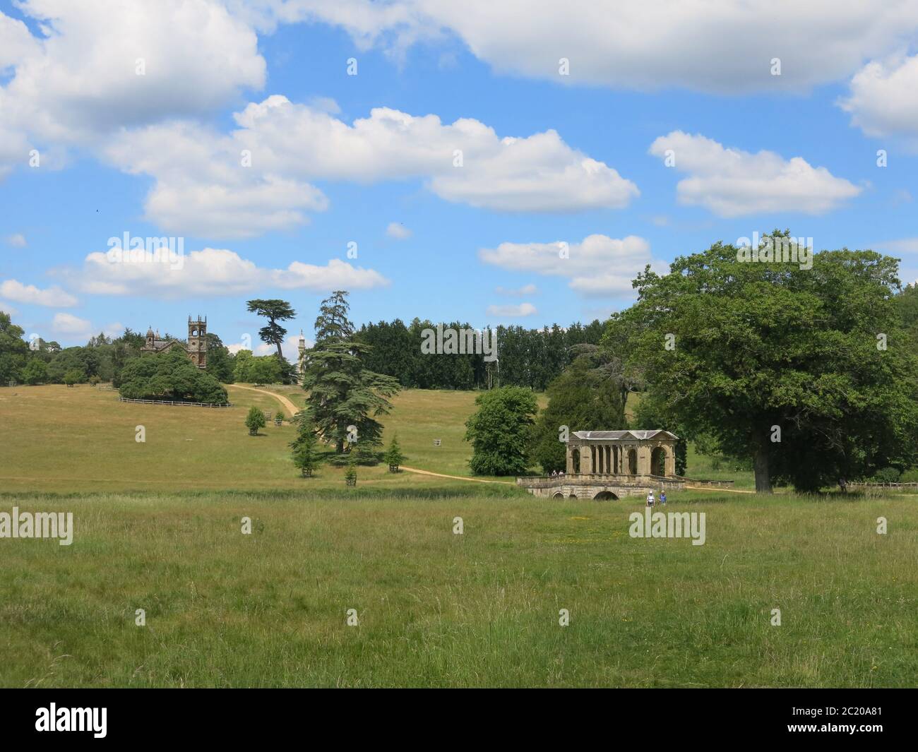 Vista del Palladian Bridge attraverso gli alberi nei giardini all'inglese di Stowe Gardens, una proprietà del National Trust nel Buckinghamshire. Foto Stock