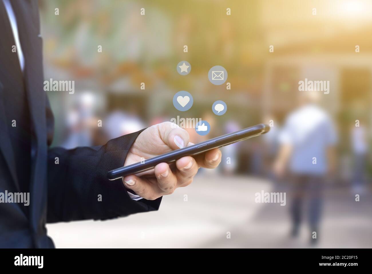 Primo piano delle mani di un uomo d'affari utilizzando lo smartphone mobile con l'icona dei social media. Idea per il business, il marketing online e la tecnologia. Foto Stock