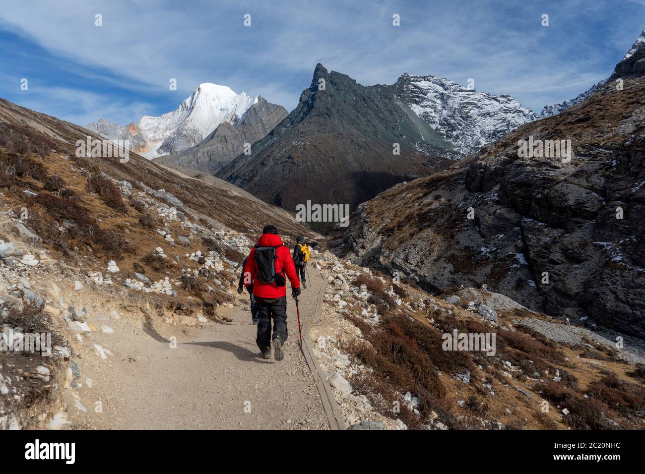 Il viaggiatore che cammina verso la catena montuosa della neve della Riserva Naturale di Yading della Cina. Foto Stock