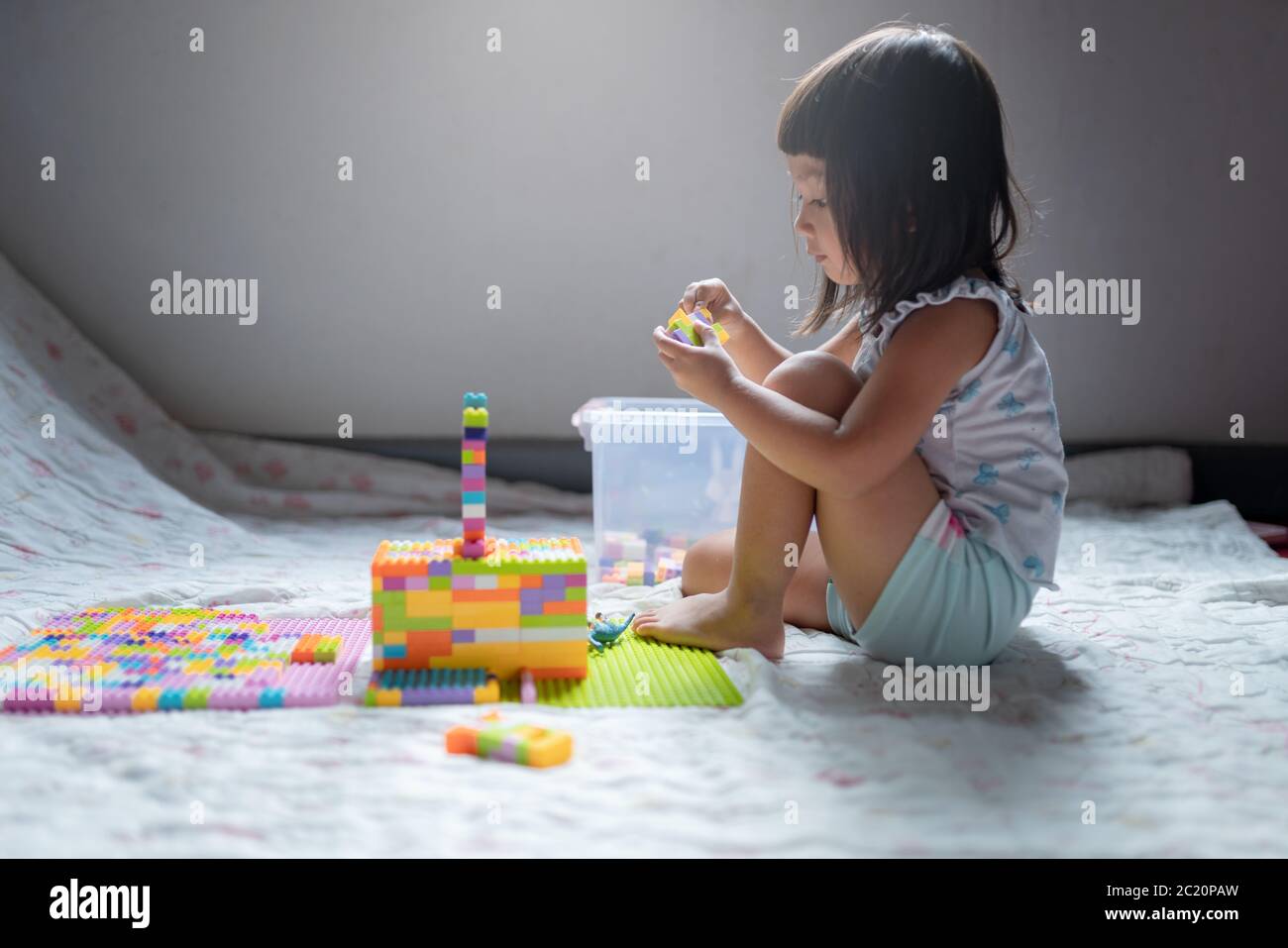 Ragazza bambino ama giocare il lego creare un edificio soggiorno a casa Foto Stock