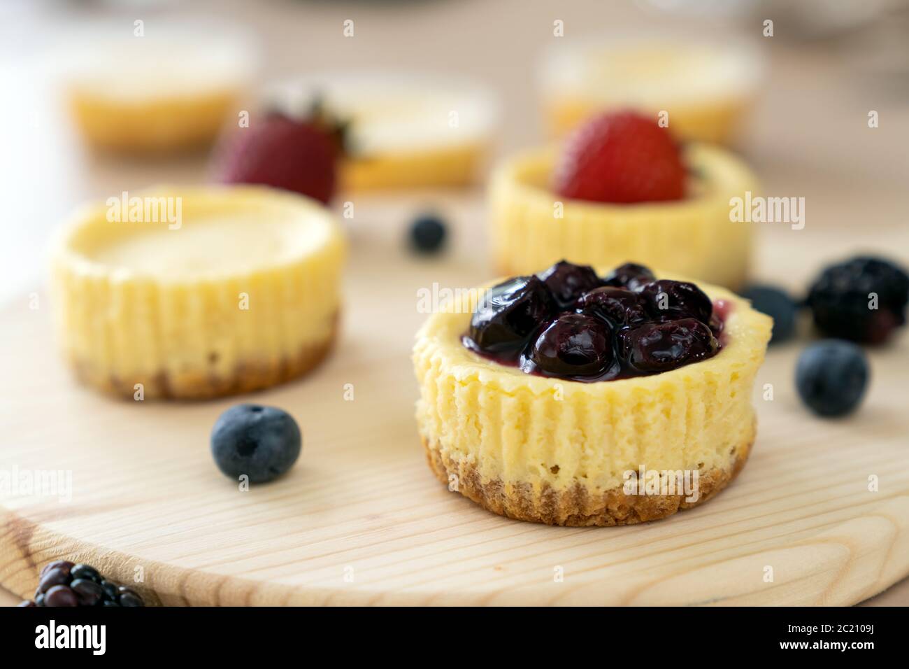 Mini cheesecake decorata con mirtillo, mora e fragola Foto Stock