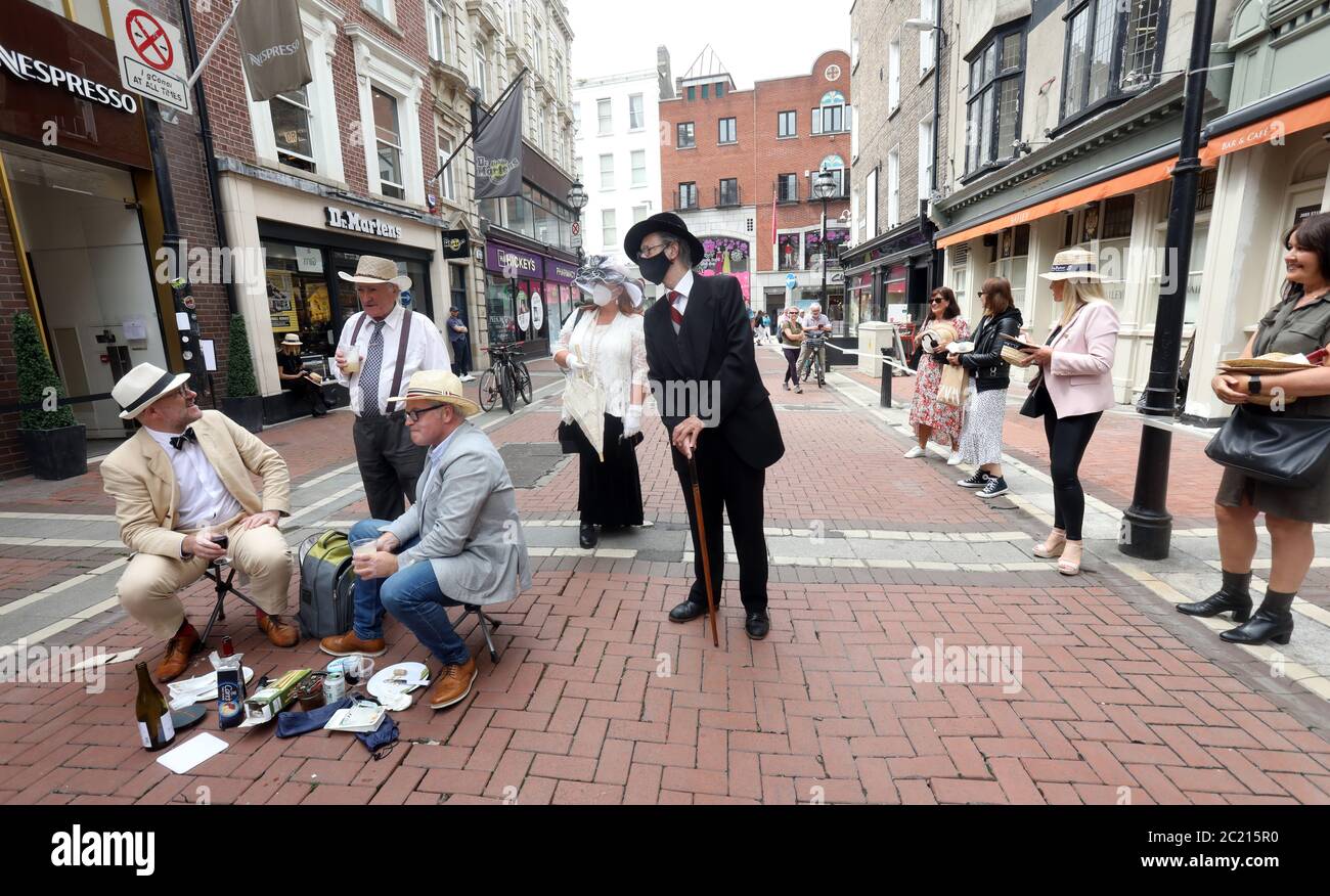 Dublino Irlanda, 16/June/2020. Bloomsday durante Covid-19 Pandemic. I fan del famoso romanzo letterario Ulysses di James Joyce, Side, hanno fatto notare che tutti gli eventi ufficiali del Bloomsday Festival sono stati annullati a causa del Lockdown, uscendo per le strade di Dublino e facendo letture al di fuori di molti dei luoghi di interesse letterario, compresi i pub, che sono ora chiusi. Foto mostra John Shevlin da Dublino vestita come James Joyce, ma indossando una maschera, chatting ad altri tifosi che hanno un picnic fuori Davy Byrnes pub a Dublino come parte delle celebrazioni. Credit: RugingNews.ie/Alamy Live News Foto Stock